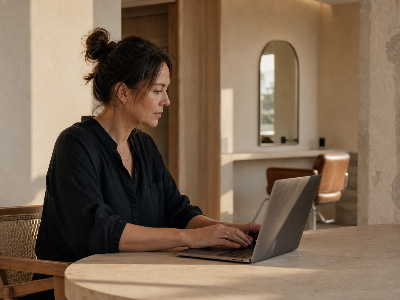 Salon owner reviewing voucher reporting on a laptop with its screen facing away